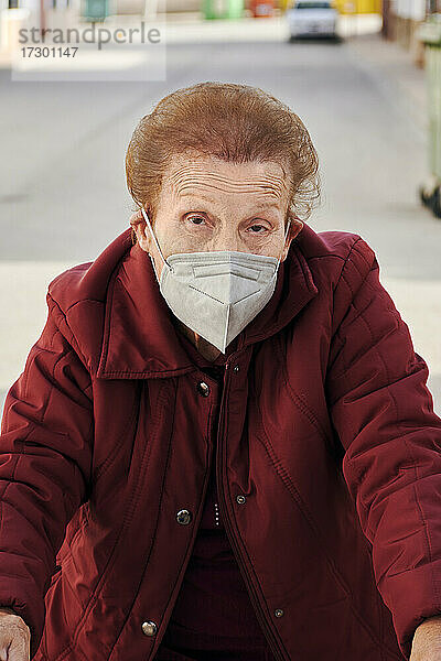 Ältere Frau schaut mit einer Gesichtsmaske in die Kamera