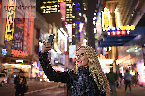 Lächelnde Frau nimmt Selfie in berühmten Stadtzentrum