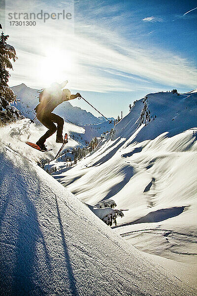 Ein Mann mit Schneeschuhen springt in der Nähe von Artist's Point von einer steilen Böschung.