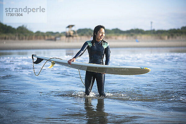 Asiatische Frau mit Spaß während Sonnenaufgang Sommer Surf-Session