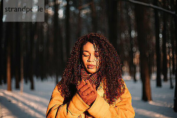 Porträt einer schönen jungen Frau im Park während des kalten Winters