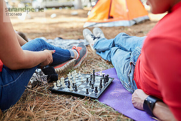 Ein paar Freunde spielen Schach vor ihrem Zelt