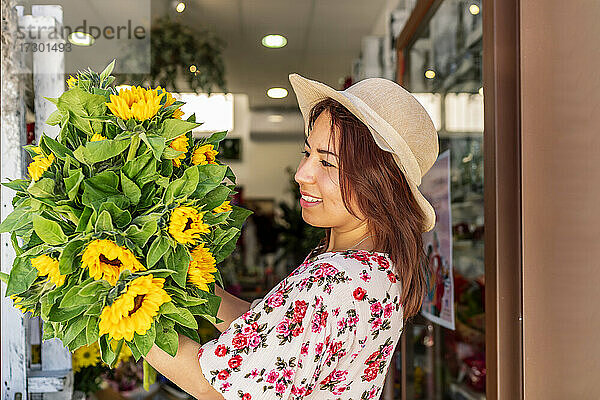 schöne Frau mit einem Strauß Sonnenblumen in den Händen