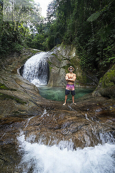 Mann genießt schönes kristallklares Wasser Regenwald Wasserfall Pool