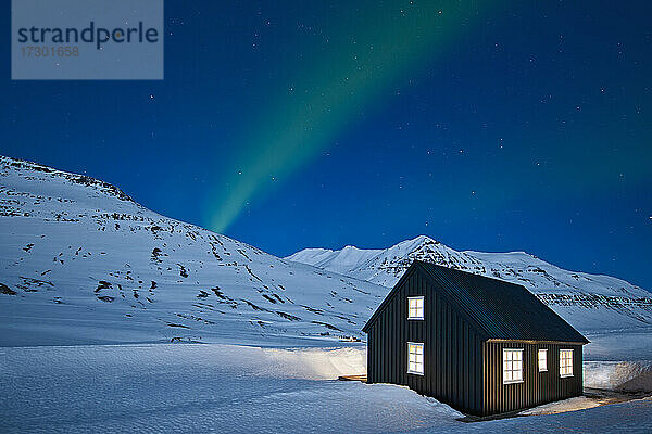 Aurora Borealis über einer abgelegenen Skihütte in Island in einer klaren Nacht