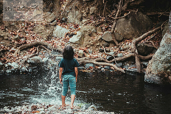 Kind amüsiert sich am Ufer eines Flusses