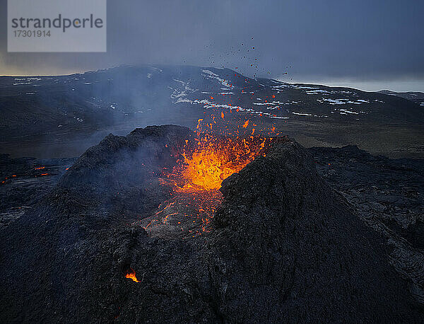 Brennende Lava spritzt in den rauen Vulkankrater