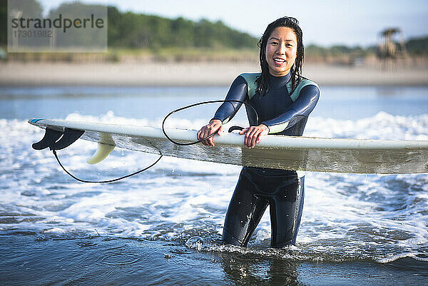 Asiatische Frau mit Spaß während Sonnenaufgang Sommer Surf-Session