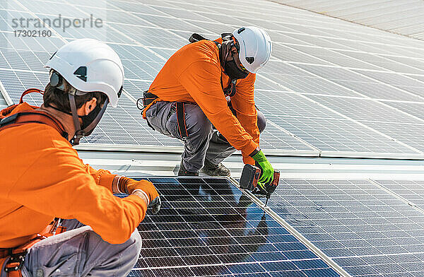 Unbekannte Solarmodultechniker arbeiten in einer spanischen Fabrik zusammen