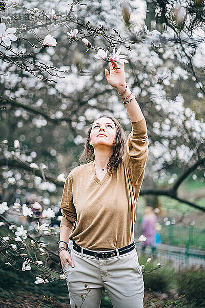 schönes Mädchen im Park mit Magnolien