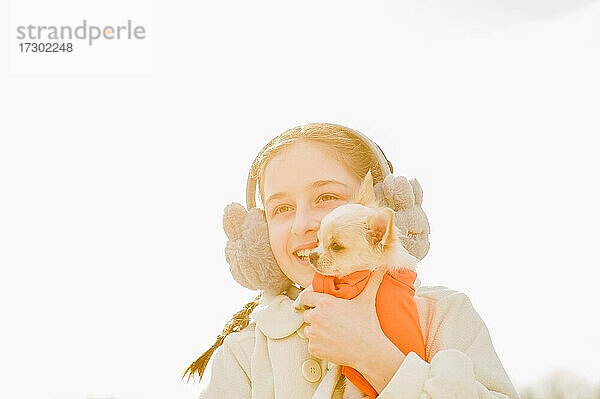 Porträt eines glücklichen Teenager-Mädchens mit ihrem kleinen Chihuahua-Hund. Ein Mädchen auf dem Hintergrund der Natur umarmt ihren Chihuahua-Hund in der Kleidung.