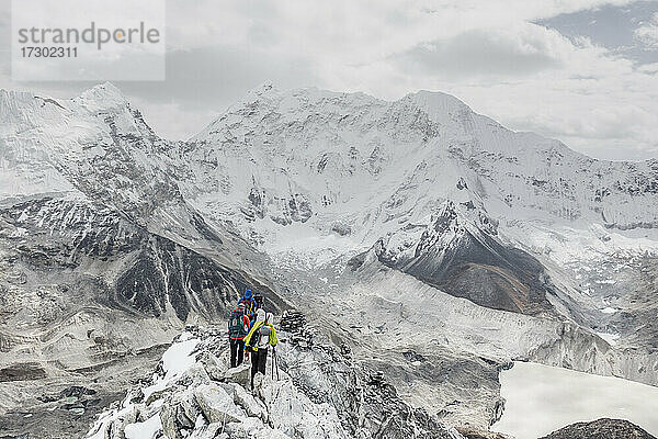 Ein Team von Alpinisten überquert einen felsigen Grat auf dem Island Peak