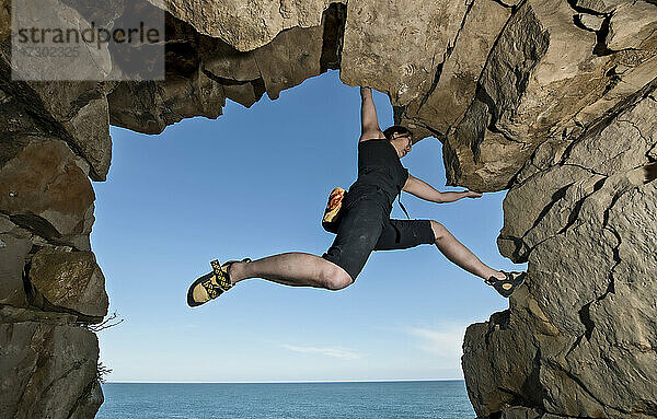 Frau beim Bouldern in einem verlassenen Steinbruch in Swanage / England