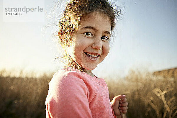 Close-up-Porträt eines lächelnden Mädchens beim Wandern an einem sonnigen Tag
