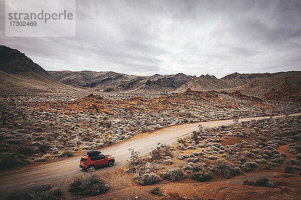 Ein orangefarbenes Auto steht auf einer Straße im Valley of Fire State Park