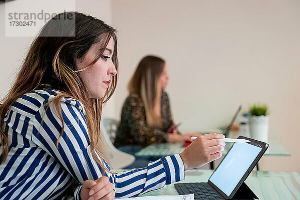 junges Mädchen arbeitet im Büro mit einem Tablet