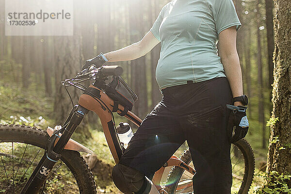 Eine schwangere junge Frau genießt das Mountainbiken in der Columbia River Gorge in Oregon.
