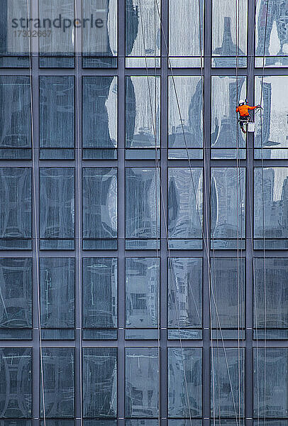 Fensterputzer bei der Arbeit an der Fassade eines Hochhauses in Bangkok