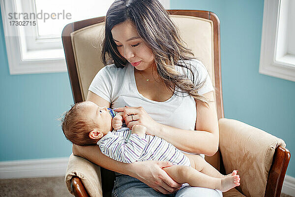 Mütter Tag Urlaub. Glückliche asiatische Mutter hält neugeborenes Baby Sohn.