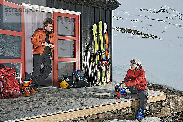 Paar bereitet sich auf Skitouren in einer Skihütte in Island vor