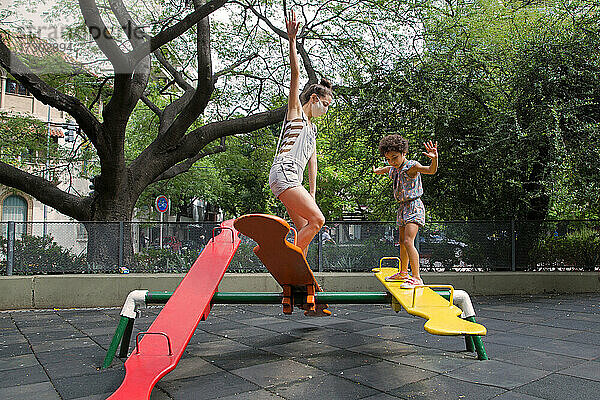 Mutter und Tochter genießen draußen auf dem Spielplatz ein neues  normales Leben.