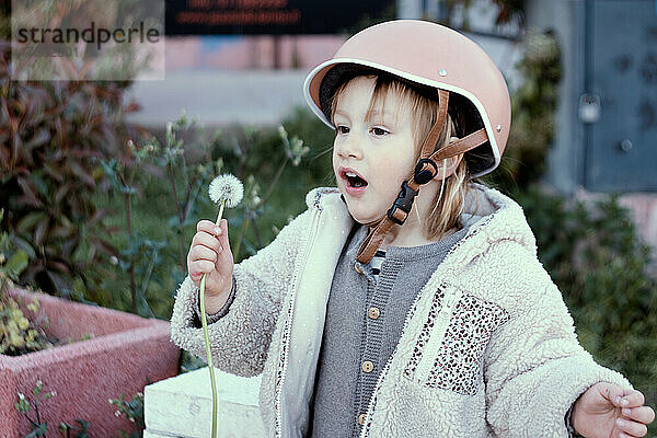 Kleines Mädchen 4 Jahre alt in einem Helm im Skatepark