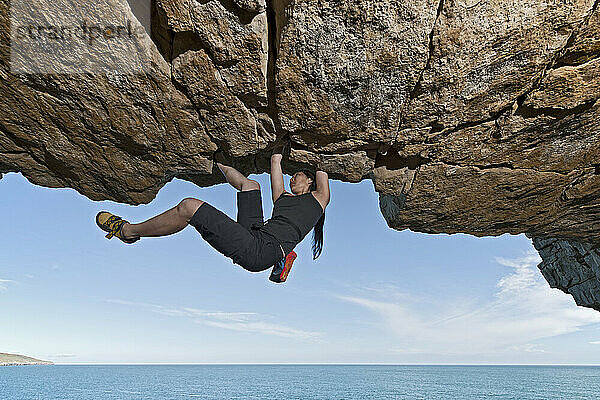 Frau beim Bouldern in einem verlassenen Steinbruch in Swanage / England