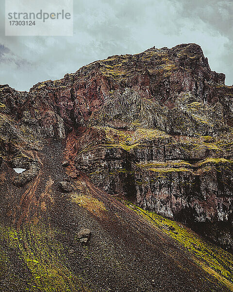 Felsgipfel in den Bergen mit grünem Moos an einem bewölkten Tag