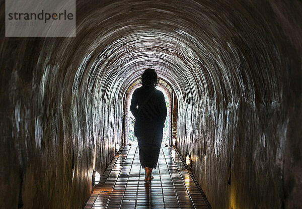 Frau geht durch die Tunnel des Tempels Wat Umong