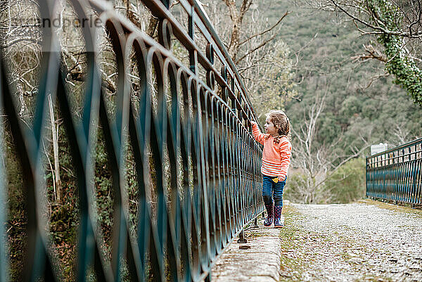 Kleines Mädchen geht entlang einer alten Metallbrücke in Frankreich