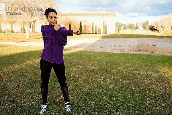 Afroamerikanische Frau mit Afro-Haar  Stretching  Aufwärmen vor dem Training