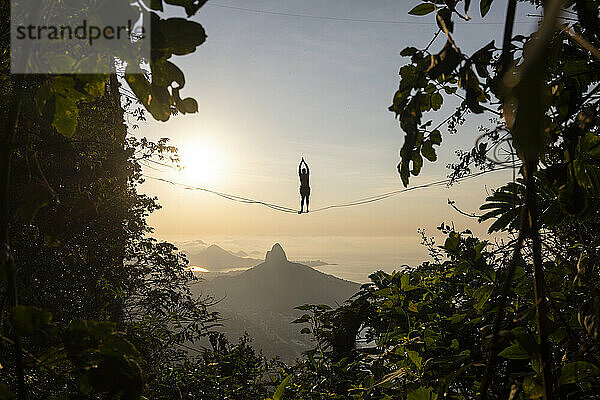 Schöne Aussicht auf männliche Highliner Silhouette auf Berg Sonnenaufgang