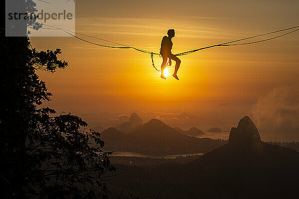 Schöner Blick auf männliche Highliner Silhouette über der Sonne auf Berg