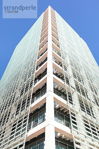 Niedriger Blickwinkel auf ein modernes weißes Gebäude mit Glasverkleidung