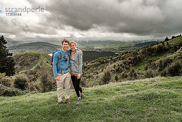 Aktives Paar mittleren Alters in Neuseeland  stehend mit Bergen im Hintergrund