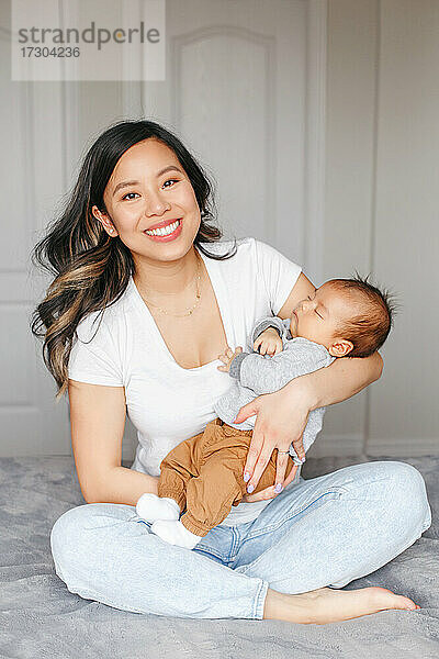 Urlaub zum Muttertag. Stolze lächelnde asiatische Mutter mit neugeborenem Baby Junge