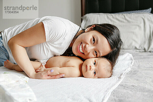 Mütter Tag Urlaub. Glückliche chinesische asiatische Mutter umarmt neugeborenen Sohn.