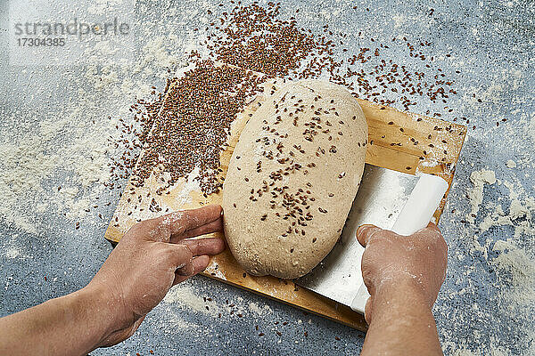 Sammeln des Teigs für handwerkliches Brot mit einem Spatel
