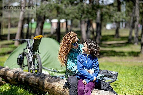 Abenteuerlustige Frau mit ihrer Tochter auf einem Campingplatz  die einen sonnigen Tag genießen