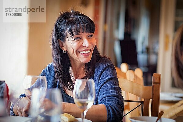 Hübsche italienische Frau genießt eine Mahlzeit und Getränke mit Freunden im Freien Restaurant