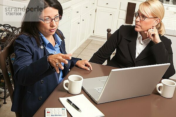 Geschäftsfrauen arbeiten gemeinsam in der Küche am Laptop