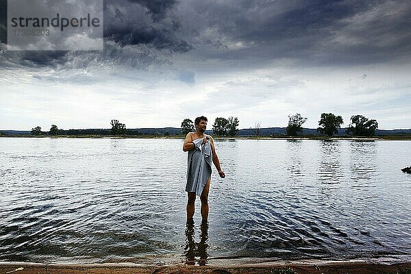 Mann badet in Elbe  Mann mit Handtuch  Elbradwanderweg  Kolonnenweg  Lochplattenweg  innerdeutsche Grenzanlage  Grünes Band  Grenzweg  UNESCO-Biosphärenreservat Flusslandschaft Elbe  Konau  Haar  Gemeinde Amt Neuhaus  Niedersachsen  Deutschland  Europa