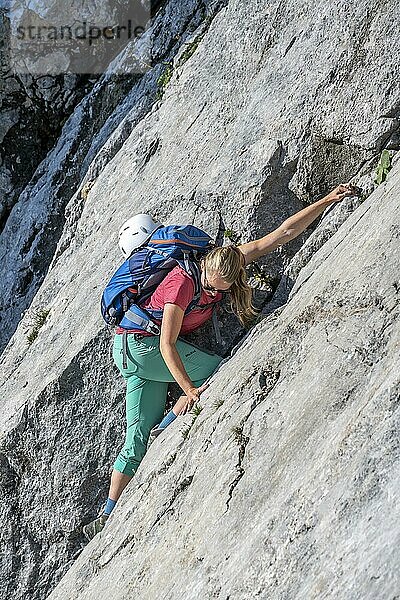 Junge Frau klettert eine Felswand entlang  Wanderung zum Hochkalter  Berchtesgadener Alpen  Berchtesgadener Land  Oberbayern  Bayern  Deutschland  Europa