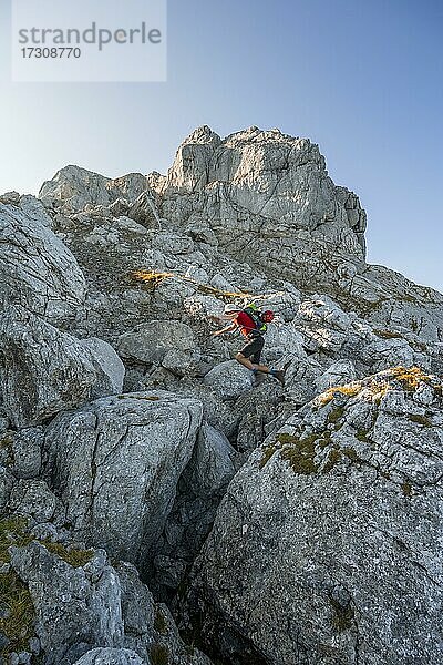 Mann springt von Felsen zu Felsen  Wanderung zum Hochkalter  Berchtesgadener Alpen  Berchtesgadener Land  Oberbayern  Bayern  Deutschland  Europa