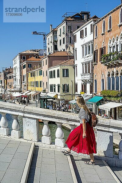 Junge Frau in Rotem Kleid geht über die Scalzi-Brücke am Canal Grande  Venedig  Venetien  Italien  Europa
