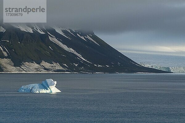 Eisberg schwimmend vor den flachen  mit Eis bedeckten Tafelbergen  Franz Josef Land Archipel  Russland  Europa
