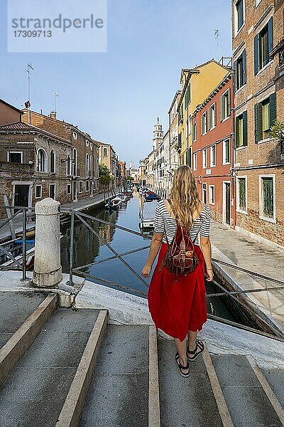 Junge Frau in Rotem Kleid blickt über einen Kanal  Venedig  Venetien  Italien  Europa