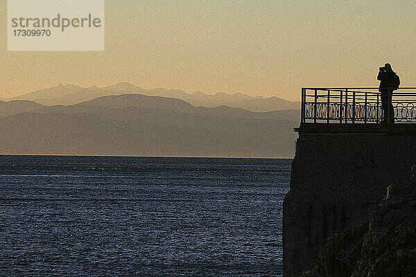 Silhouetted Tourist Blick auf Meer und Berg Blick in der Abenddämmerung  Ligurien  Italien