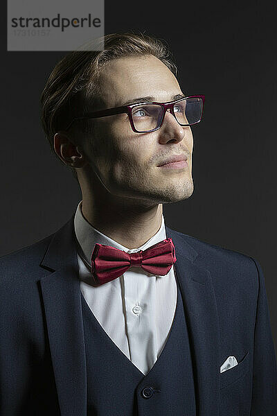 Porträt nachdenklicher  gut aussehender junger Mann in Anzug und Brille