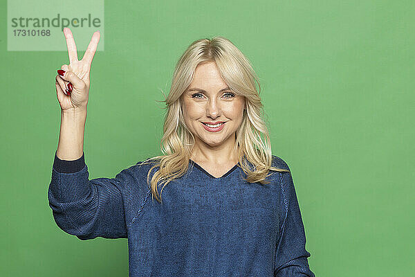 Porträt glückliche blonde Frau gestikulieren Friedenszeichen